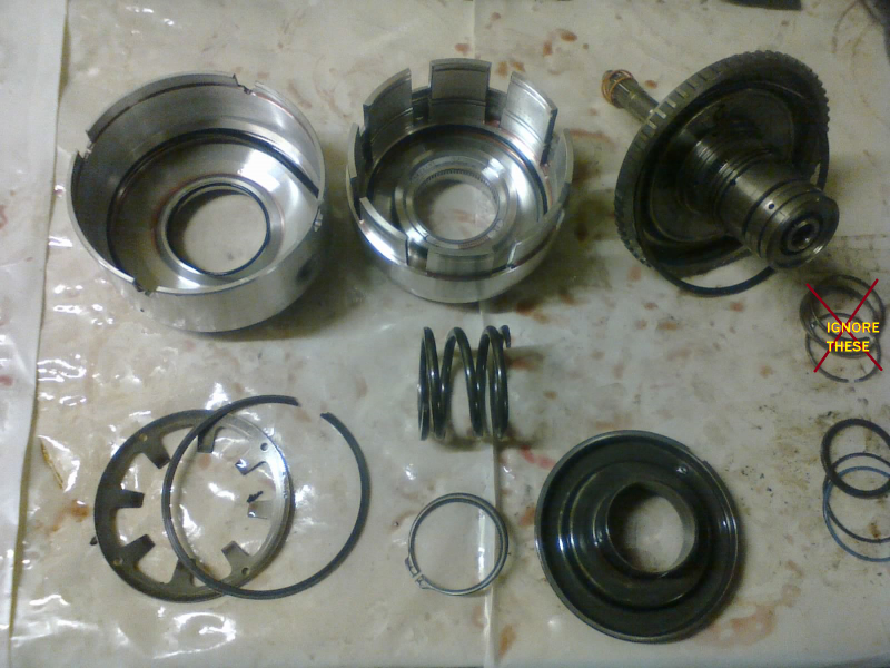 First, we’ll start gathering some parts for cleaning. The rebuild kit provides a new underdrive return spring retainer (not pictured).